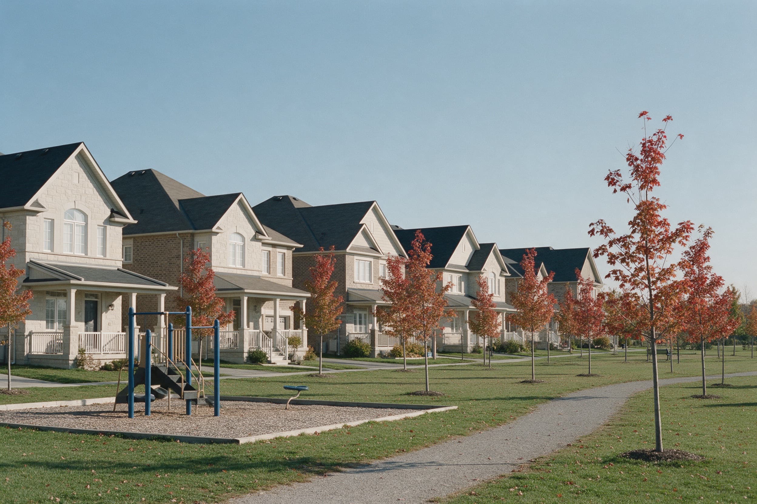 New detached homes facing a neighbourhood park in autumn